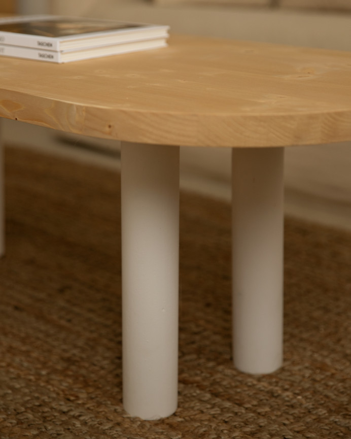 Mesa de centro ovalada de madera maciza sobre en tono roble medio y patas tono blanco de 40x120cm