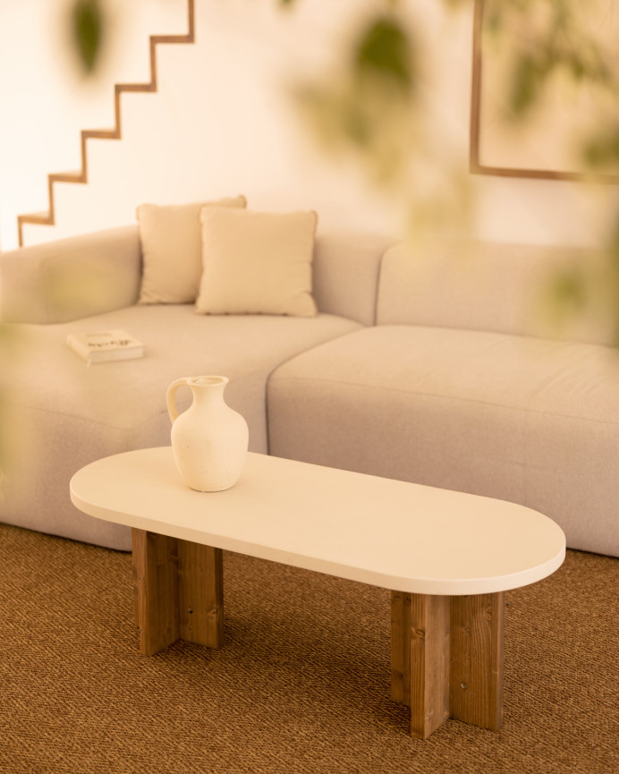 Mesa de centro de microcemento en tono blanco roto con patas de madera tono roble oscuro de 120x50cm