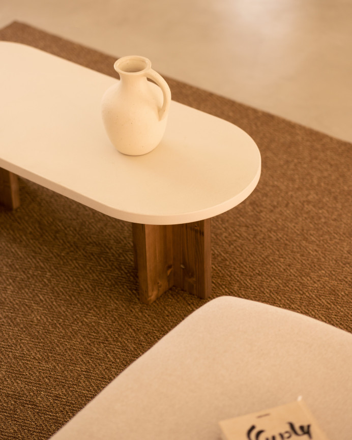Mesa de centro de microcemento en tono blanco roto con patas de madera tono roble oscuro de 120x50cm