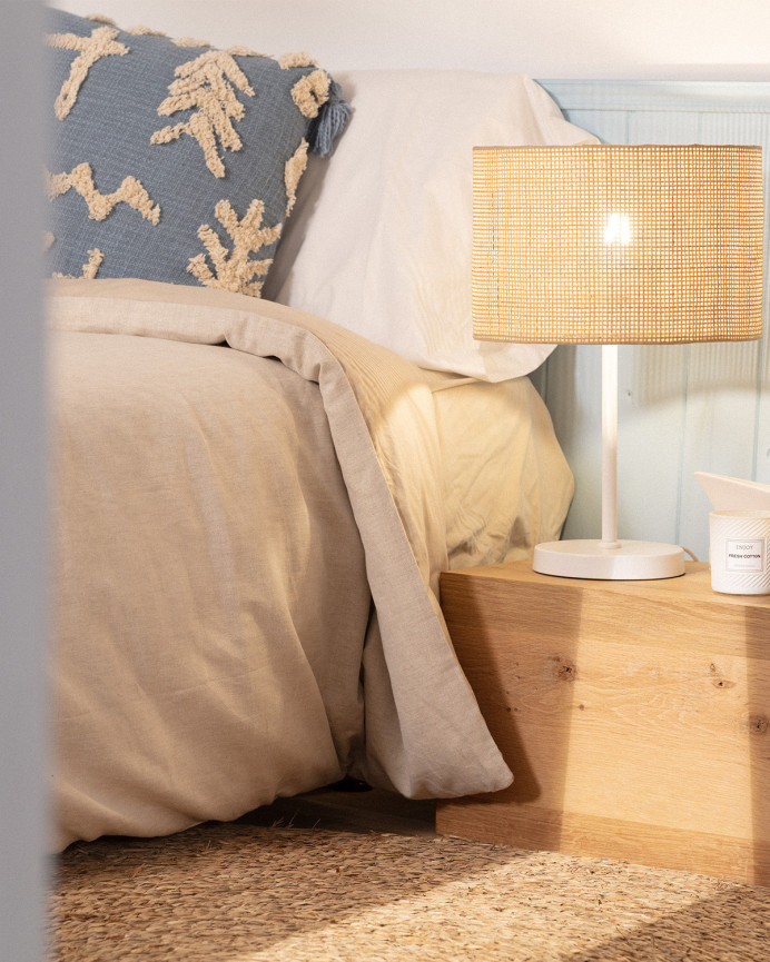Lampe de table composée d'une base en métal blanc et d'un abat-jour en rotin