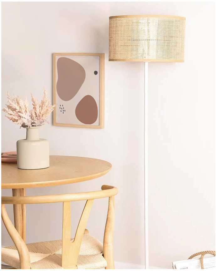 Lampadaire composé d'une base en métal blanc et d'un écran en rotin