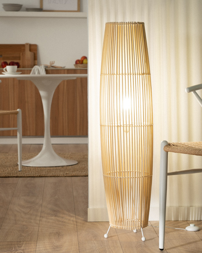 Lampadaire composé d'une base en métal blanc et de branches de bambou reliées par une tresse de fibres naturels