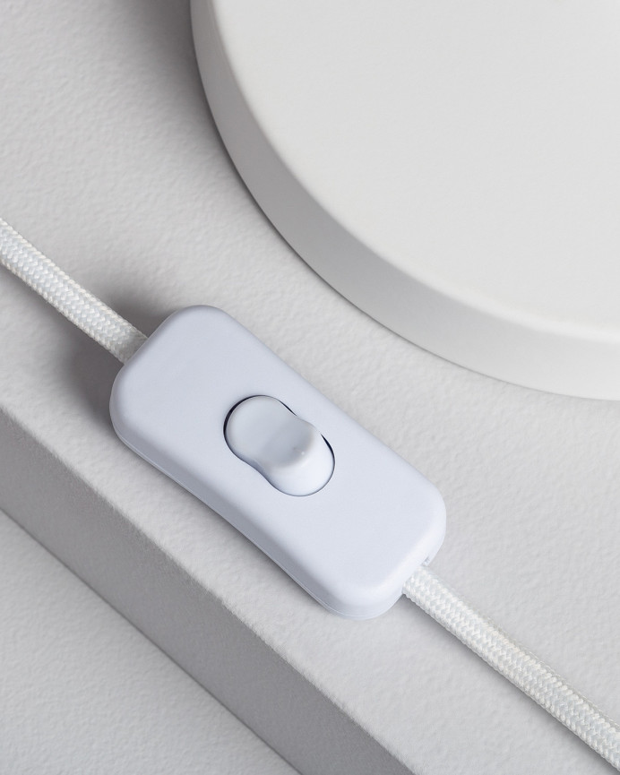 Lampe de table composée d'une base en métal blanc et d'un abat-jour en rotin