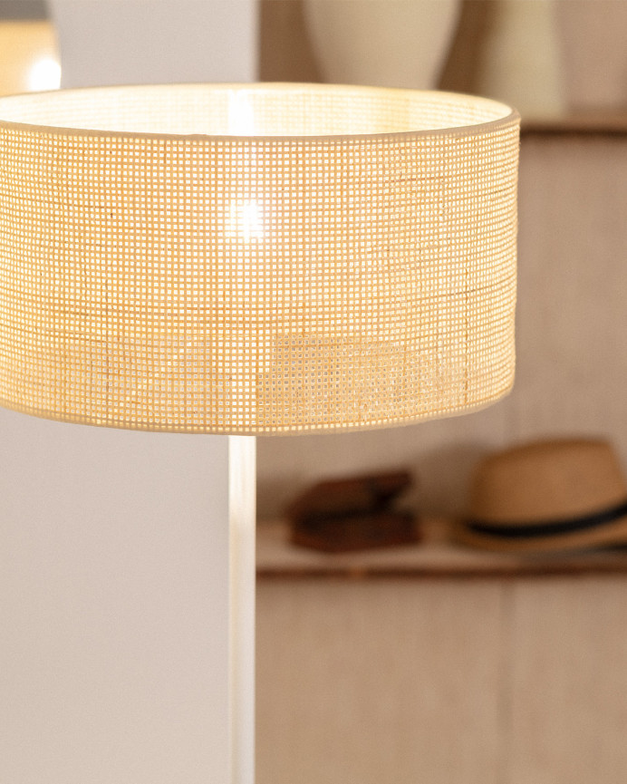 Lampadaire composé d'une base en métal blanc et d'un écran en rotin