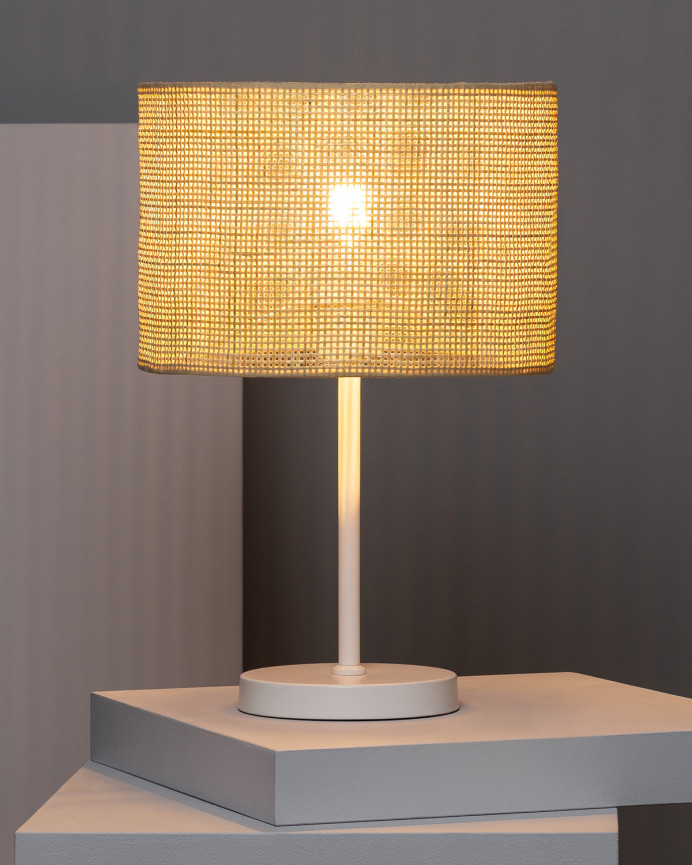 Lampe de table composée d'une base en métal blanc et d'un abat-jour en rotin
