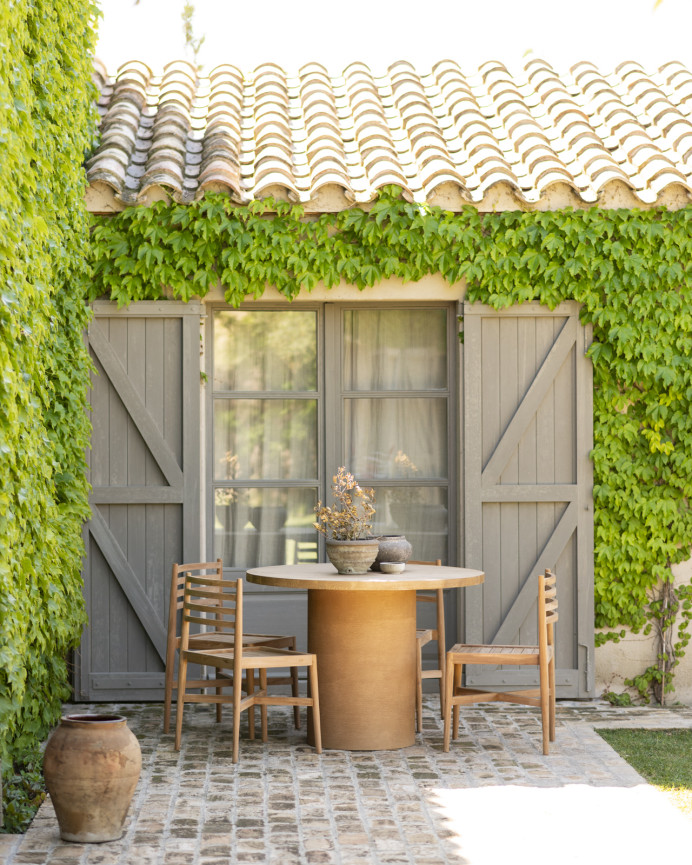 Table de salle à manger ronde en bois massif teinte chêne moyen pieds en microciment teinte terracotta en différentes tailles