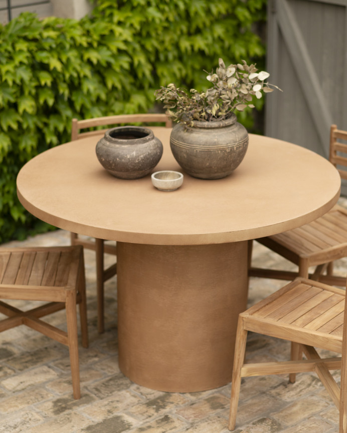 Table de salle à manger ronde en microciment de teinte terracotta disponible en différentes tailles